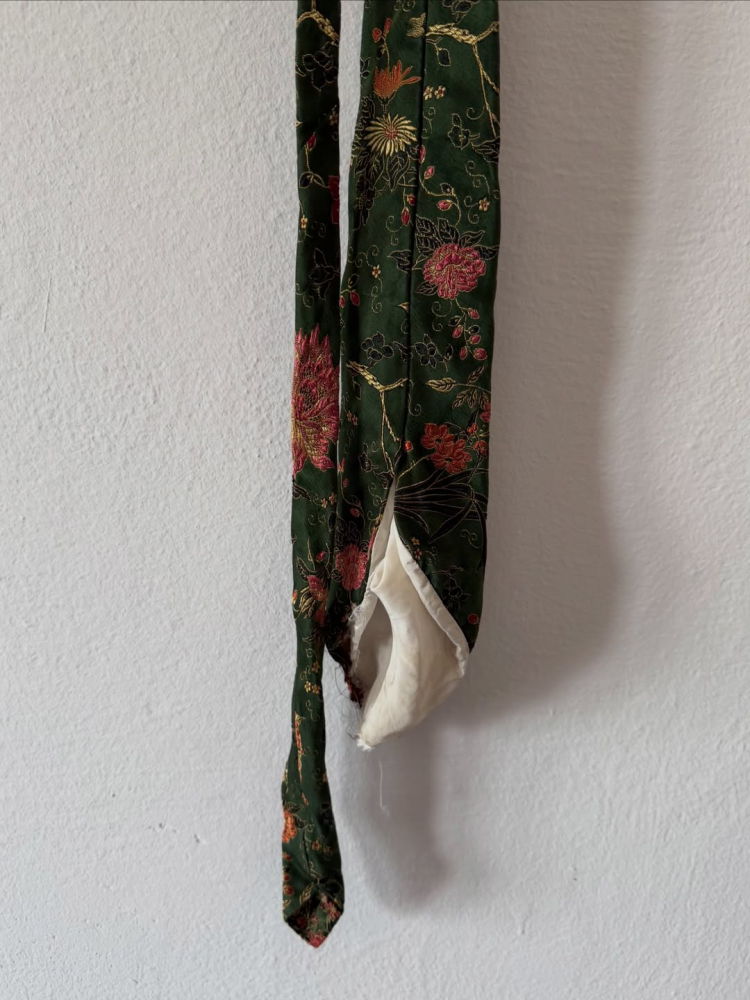 Damaged silk tie inherited from grandfather, close-up of damage